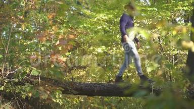 人在公园里爬树。 英俊的男人秋天的自然背景。 爬树人。 秋高气爽的秋人